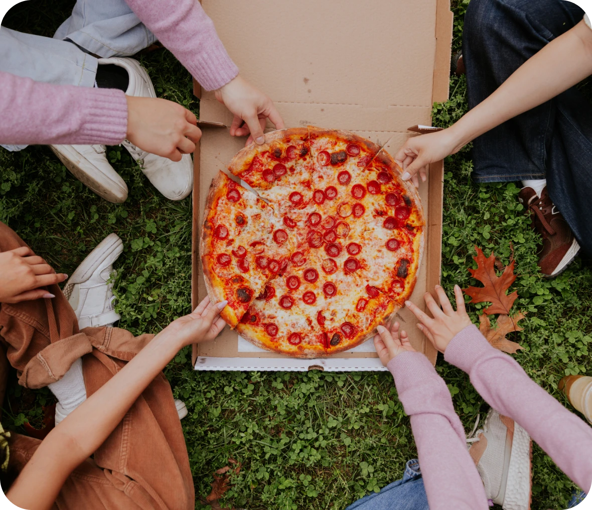 Friends enjoying pizza picnic